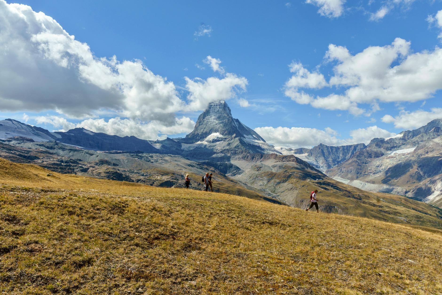 Turyści na górskim szlaku z widokiem na Matterhorn w okolicach Zermatt