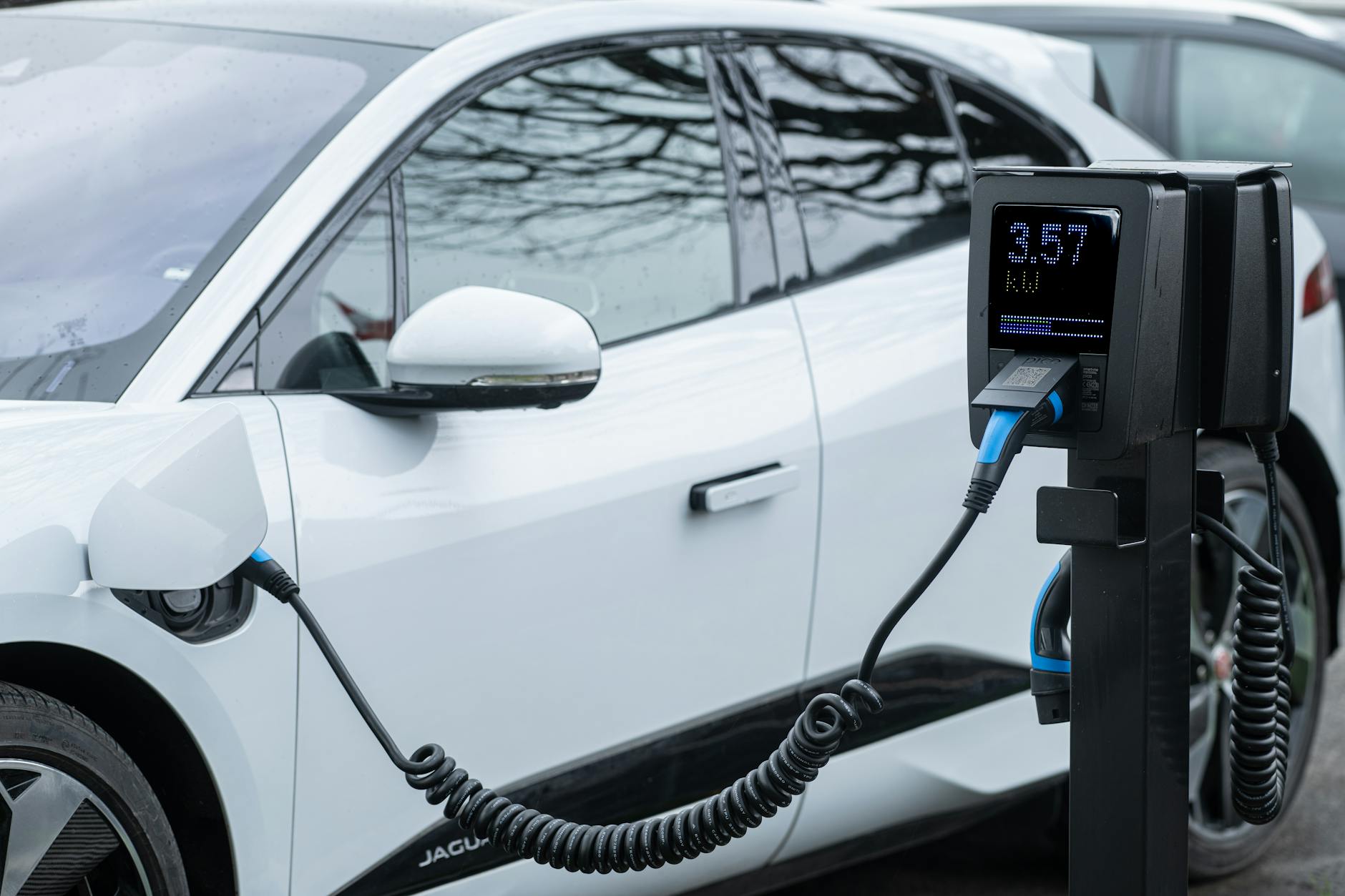 Zbliżenie na ładowanie elektrycznego auta Mitsubishi przy stacji
