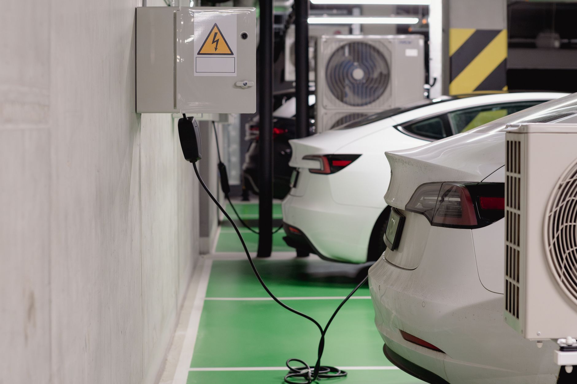 Elektryczne auta ładujące się w nowoczesnym podziemnym garażu