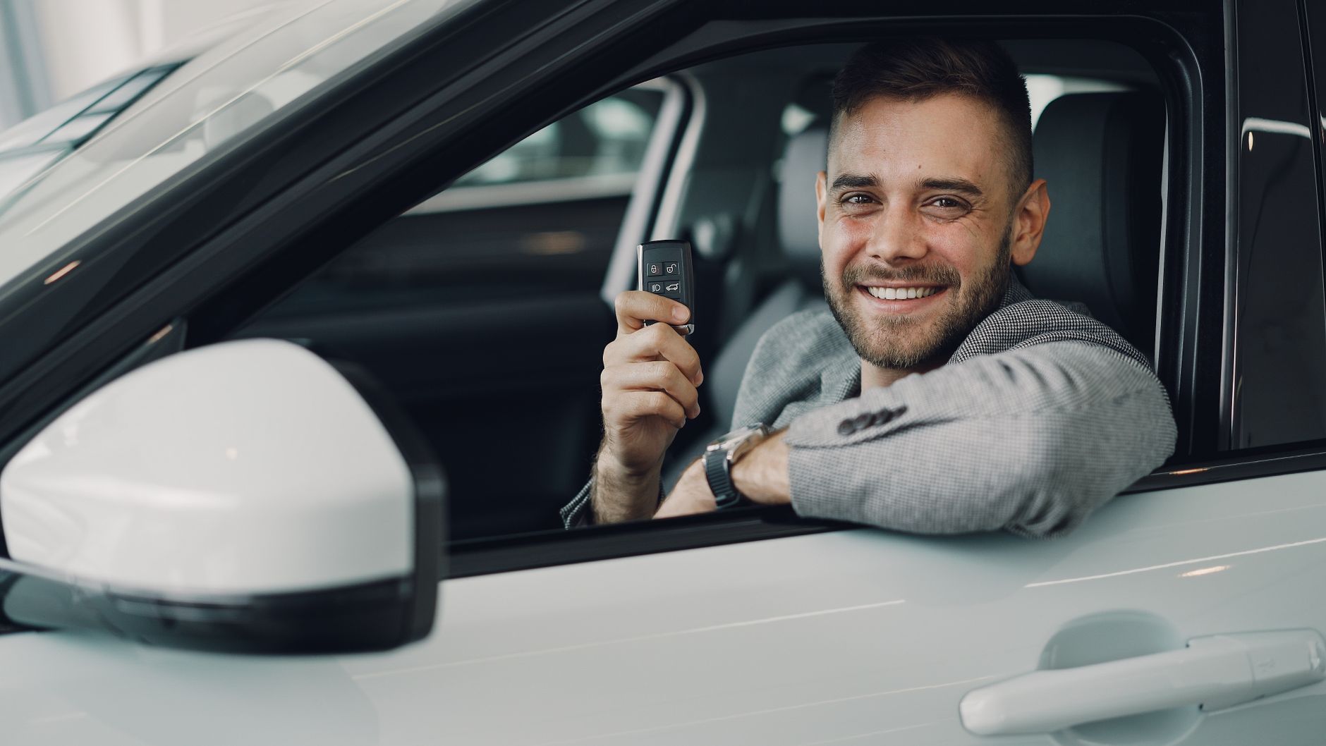 Student siedzi w BMW serii 1 i z uśmiechem trzyma kluczyki