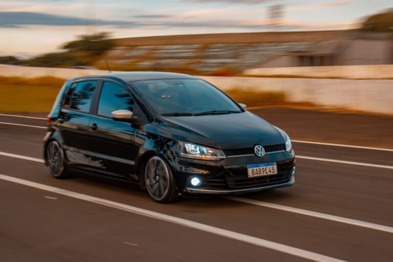 Czarny Volkswagen hatchback jadący szybko po drodze