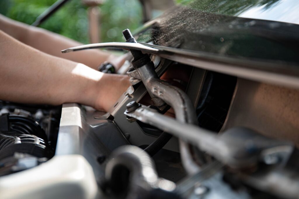 Mechanik naprawiający silnik samochodowy przy użyciu narzędzi